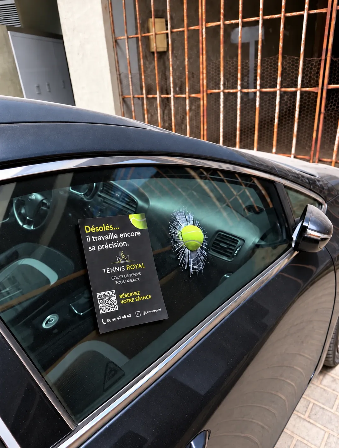 Balle de tennis en trompe-l'œil sur la vitre d'une voiture